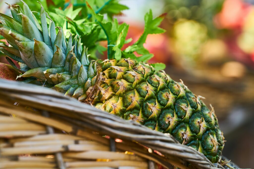 Close-up of a ripe pineapple in a basket, highlighting its fresh and juicy appeal.